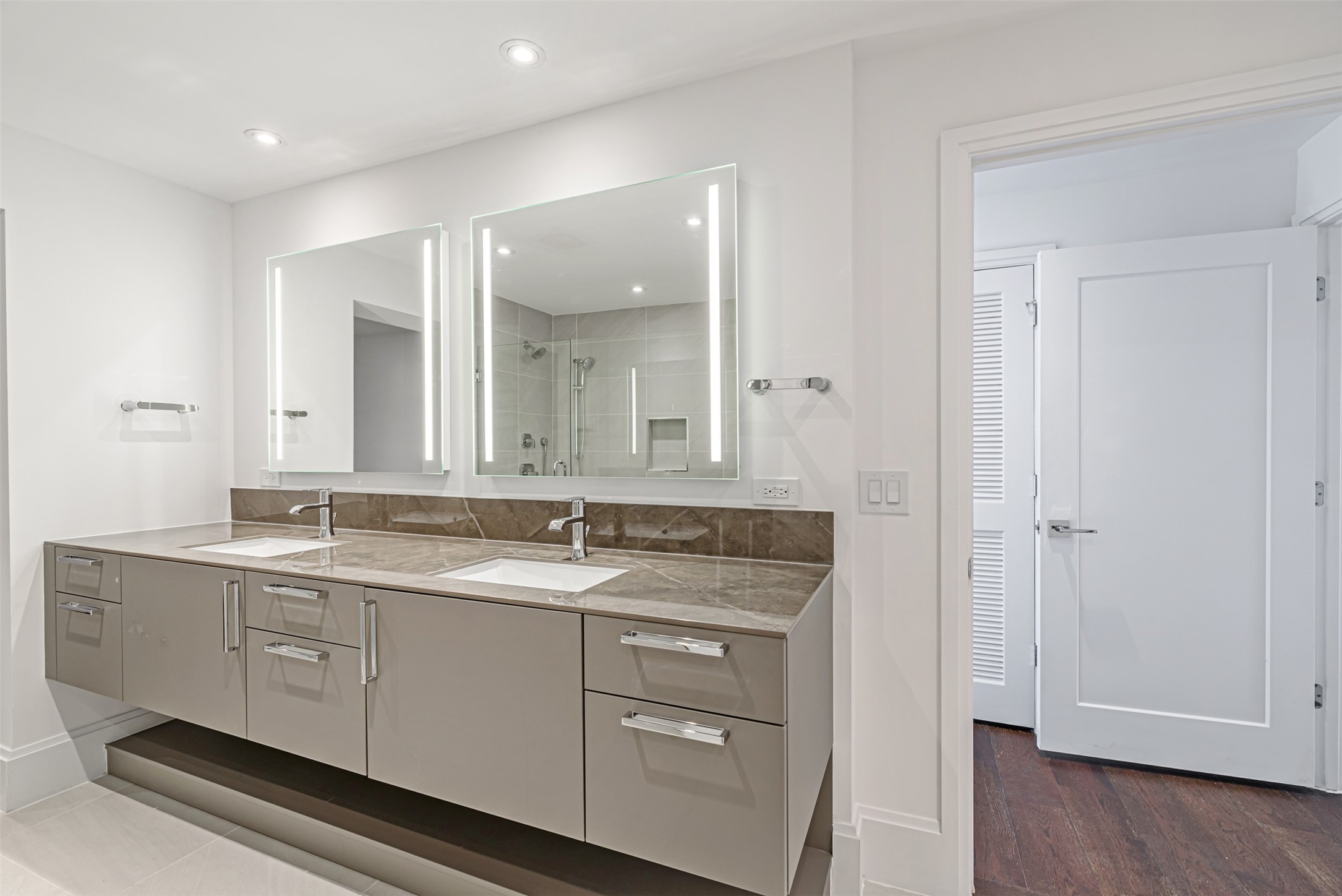 1701 Hermann Drive, Unit 34L Houston, TX 77004 - Photo 15 of 37 The dual vanity boasts undermount sinks, backlit vanity mirrors and thoughtfully placed LED recessed lighting.