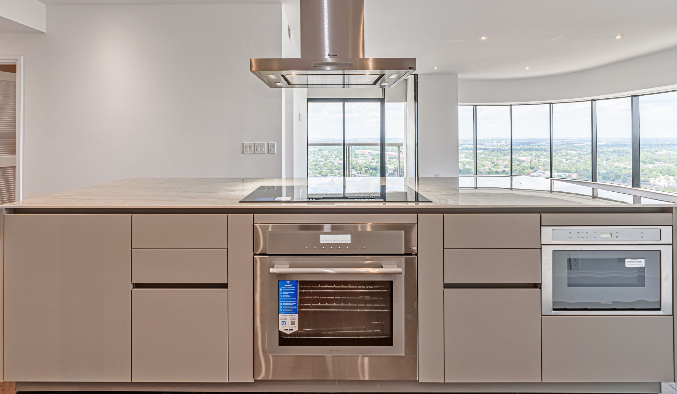 1701 Hermann Drive, Unit 34L Houston, TX 77004 - Photo 10 of 37 This show stopper island with Thermador Induction Cooktop, microwave drawer and convection oven provides ample seating and anchors the heart of the home.