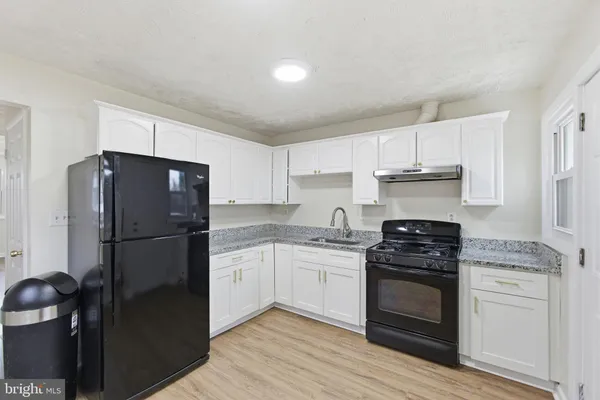 a kitchen with a refrigerator stove and white cabinets