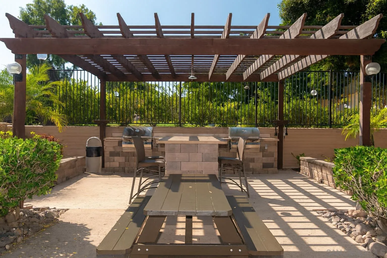 4032 Valeta Street, Unit 319 San Diego, CA 92110 - Photo 13 of 17 a view of a patio with table and chairs under an umbrella with a barbeque