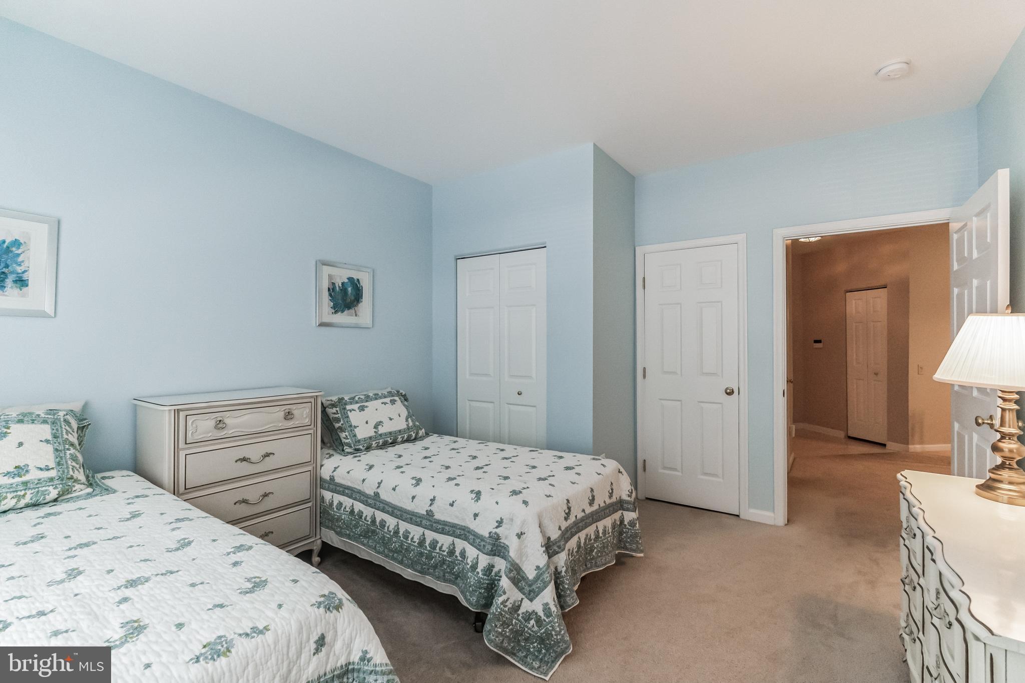200 Beech Boulevard, Unit 104 Warrington, PA 18976 - Photo 22 of 30 a bedroom with a bed and a lamp on dresser