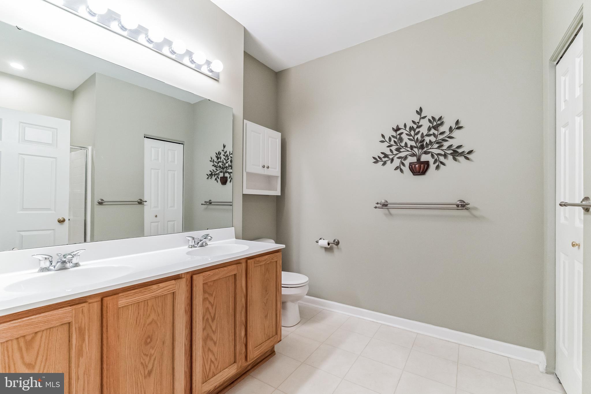 200 Beech Boulevard, Unit 104 Warrington, PA 18976 - Photo 27 of 30 a bathroom with a sink a toilet and mirror