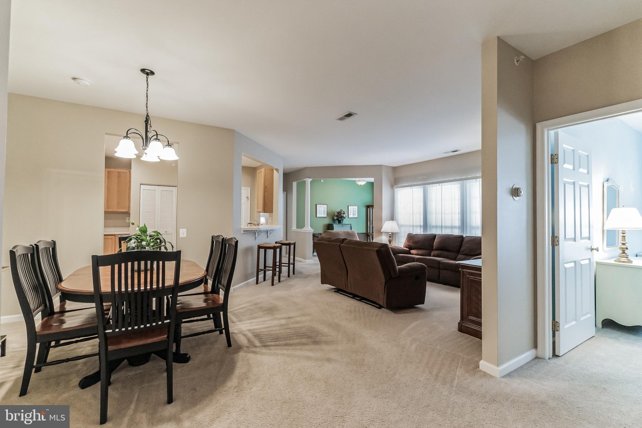 200 Beech Boulevard, Unit 104 Warrington, PA 18976 - Photo 5 of 30 a living room with furniture a chandelier and a dining table