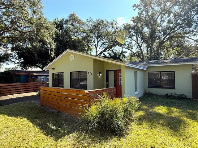 a front view of house with yard and trees in the background