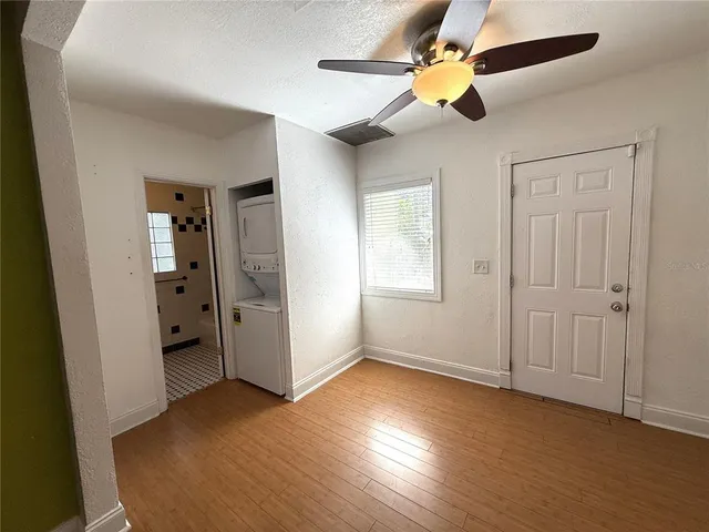 an empty room with ceiling fan and window