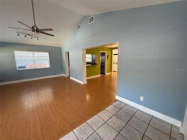 a view of an empty room with window and wooden floor