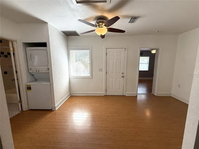 an empty room with window and ceiling fan
