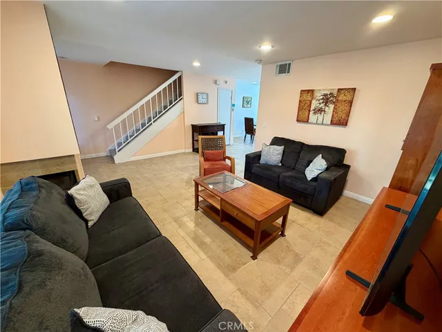 a living room with furniture and stairs