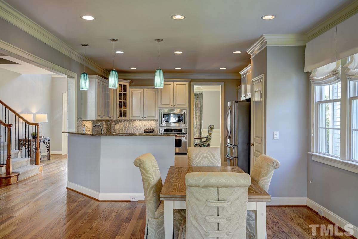2724 Peachleaf Street Raleigh, NC 27614 - Photo 15 of 45 a dining room with stainless steel appliances kitchen island granite countertop furniture and wooden floor