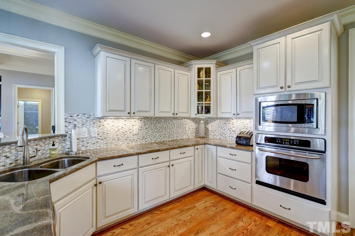 2724 Peachleaf Street Raleigh, NC 27614 - Photo 16 of 45 a kitchen with white cabinets sink and stainless steel appliances