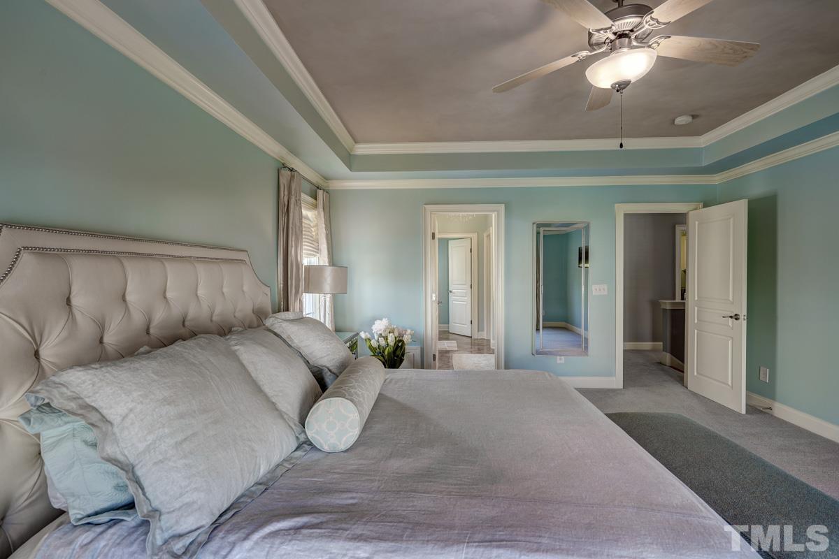 2724 Peachleaf Street Raleigh, NC 27614 - Photo 28 of 45 a bedroom with a large bed and a chandelier