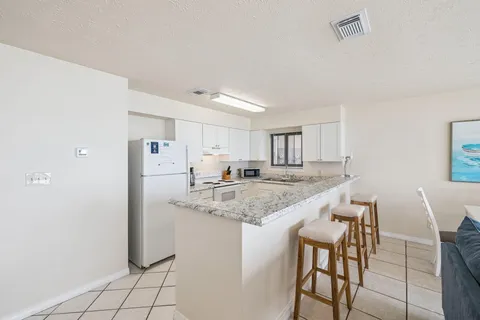 a kitchen with white cabinets sink and white appliances