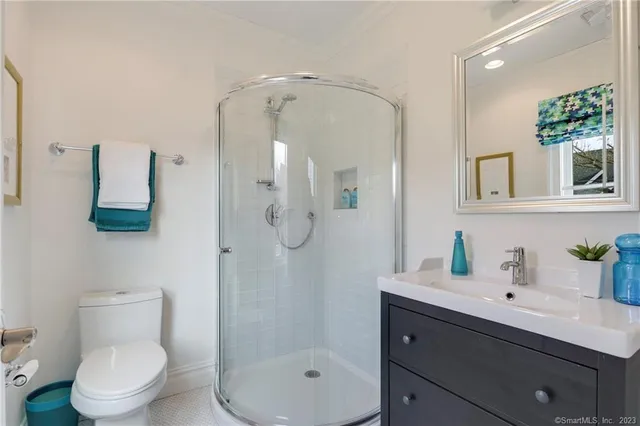 a bathroom with a sink a toilet and shower