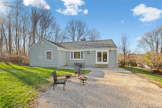 a backyard of a house with table and chairs