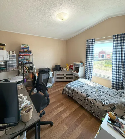 a bedroom with furniture and a wooden floor
