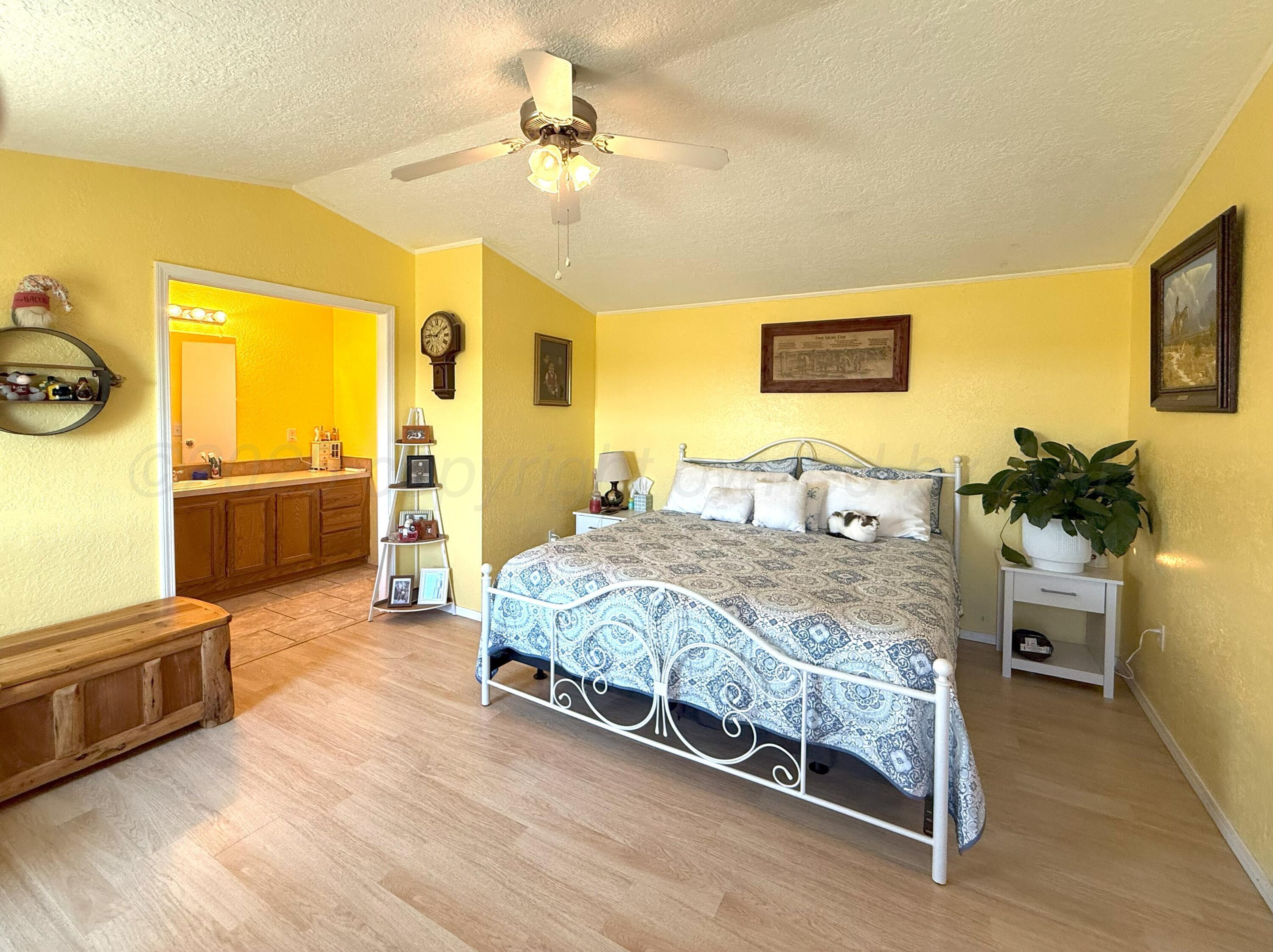 1405 County Road 17 Panhandle, TX 79068 - Photo 7 of 14 a spacious bedroom with a bed and wooden floor