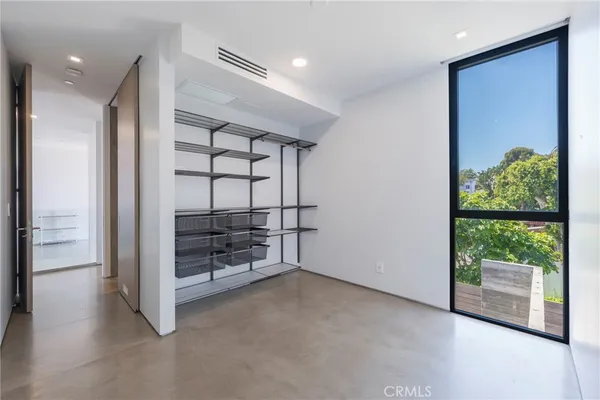a view of an empty room with a floor to ceiling window and wooden floor