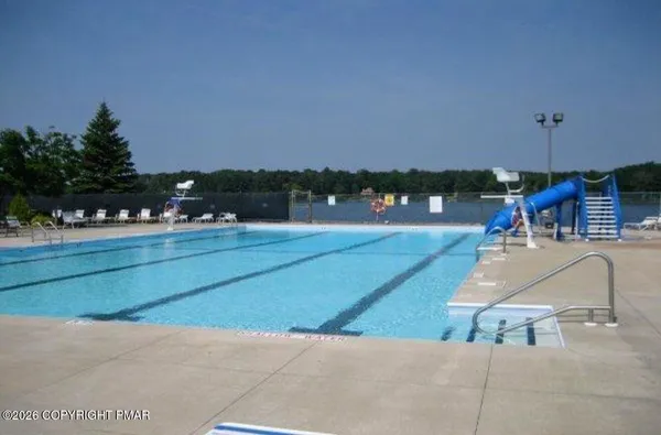 a swimming pool with outdoor seating and yard