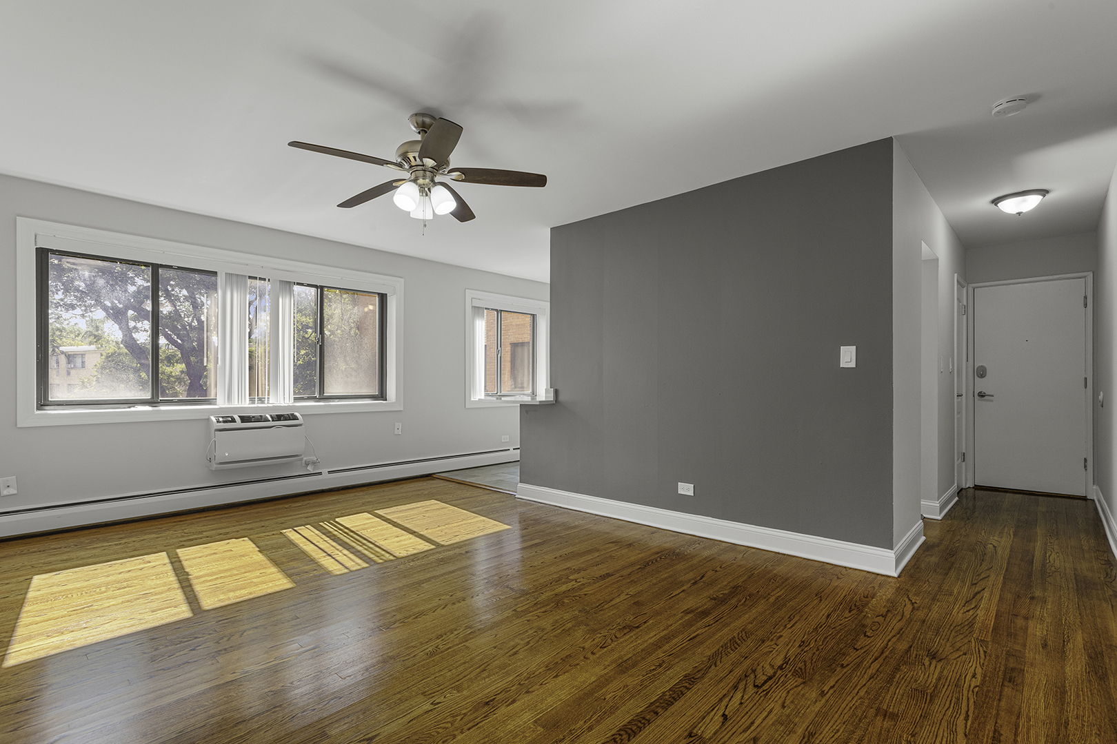 6826 North Ridge Boulevard, Unit 201 Chicago, IL 60645 - Photo 2 of 13 a view of an empty room with window and wooden floor