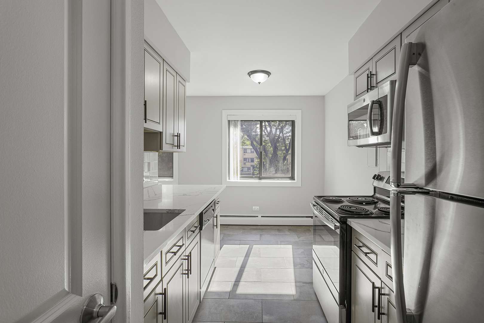 6826 North Ridge Boulevard, Unit 201 Chicago, IL 60645 - Photo 5 of 13 a kitchen with stainless steel appliances granite countertop a refrigerator a stove and a sink