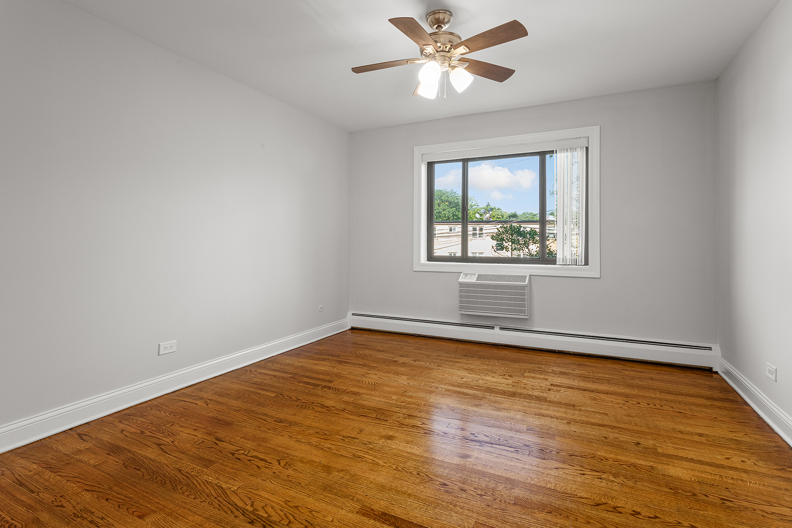 6826 North Ridge Boulevard, Unit 201 Chicago, IL 60645 - Photo 9 of 13 a view of an empty room with wooden floor and a window
