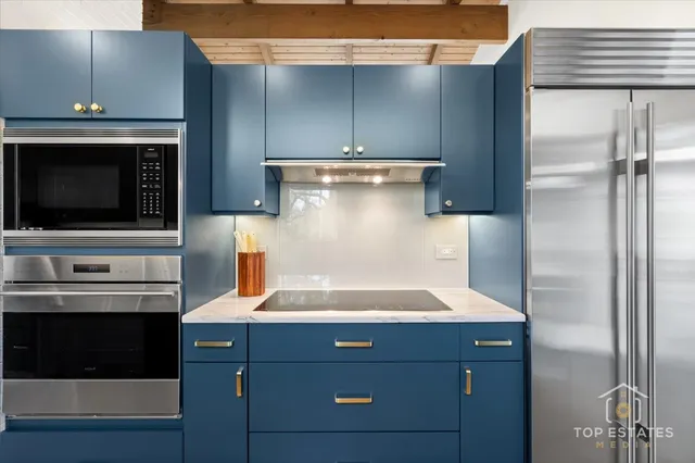 a kitchen with stainless steel appliances a stove and a microwave