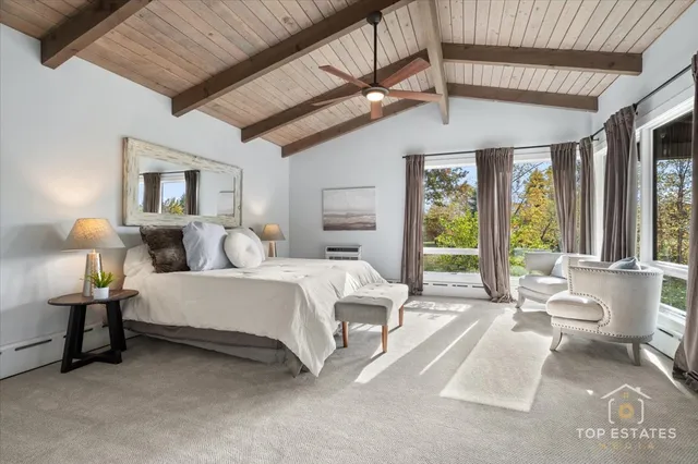 a spacious bedroom with a bed couch and a large window