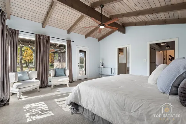 a spacious bedroom with a bed glass walk in closet and a window