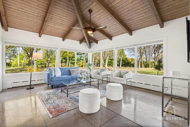 a living room with patio furniture and a large window