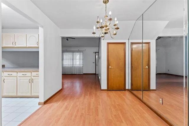 a view of a kitchen with wooden floor and refrigerator