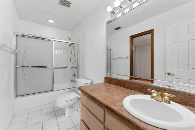 a bathroom with a granite countertop sink toilet mirror and shower
