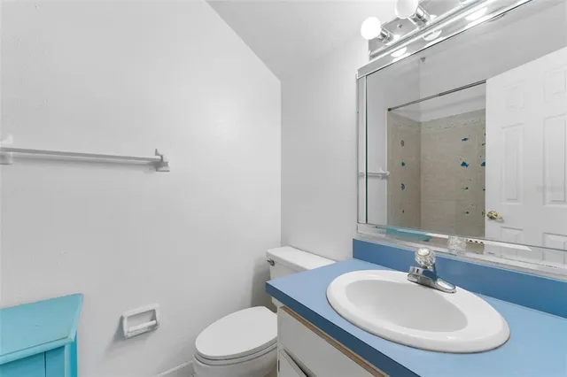 a bathroom with a sink a toilet and mirror