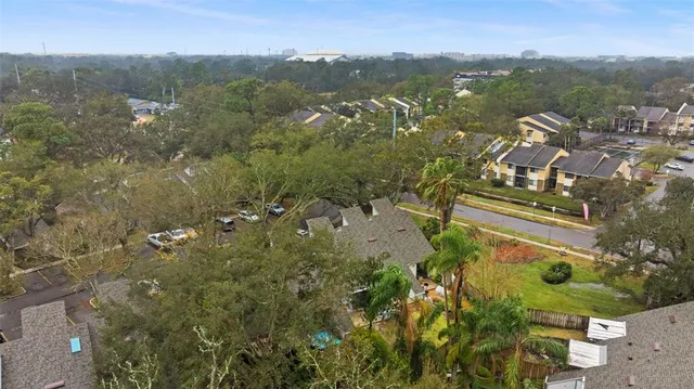 an aerial view of residential house with outdoor space and trees all around