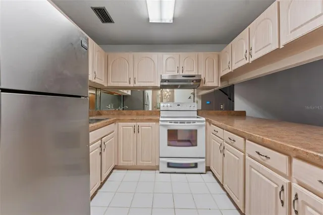 a kitchen with white cabinets and white appliances