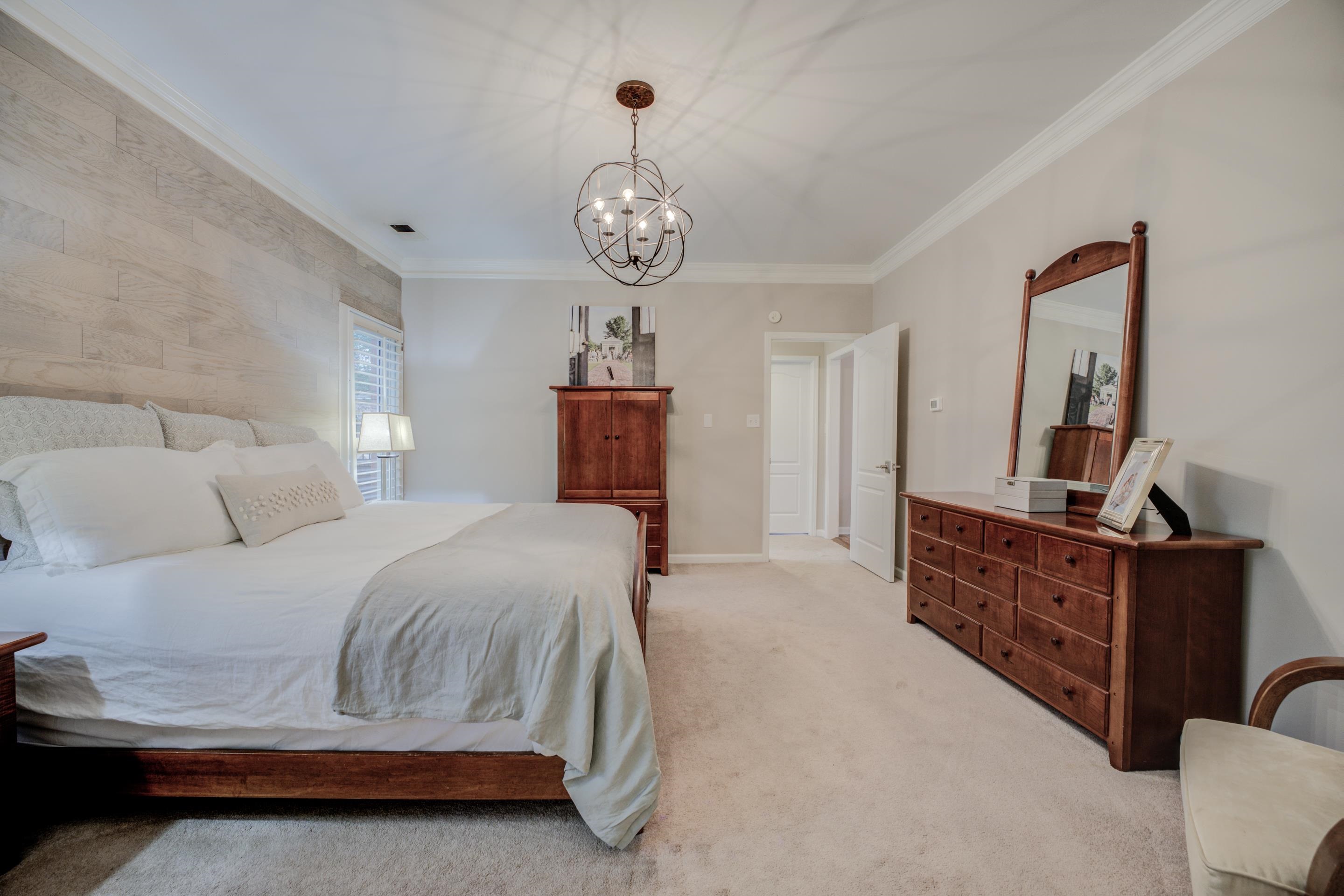 1594 John Ridge Drive Collierville, TN 38017 - Photo 15 of 29 Bedroom featuring light colored carpet, crown molding, and an inviting chandelier