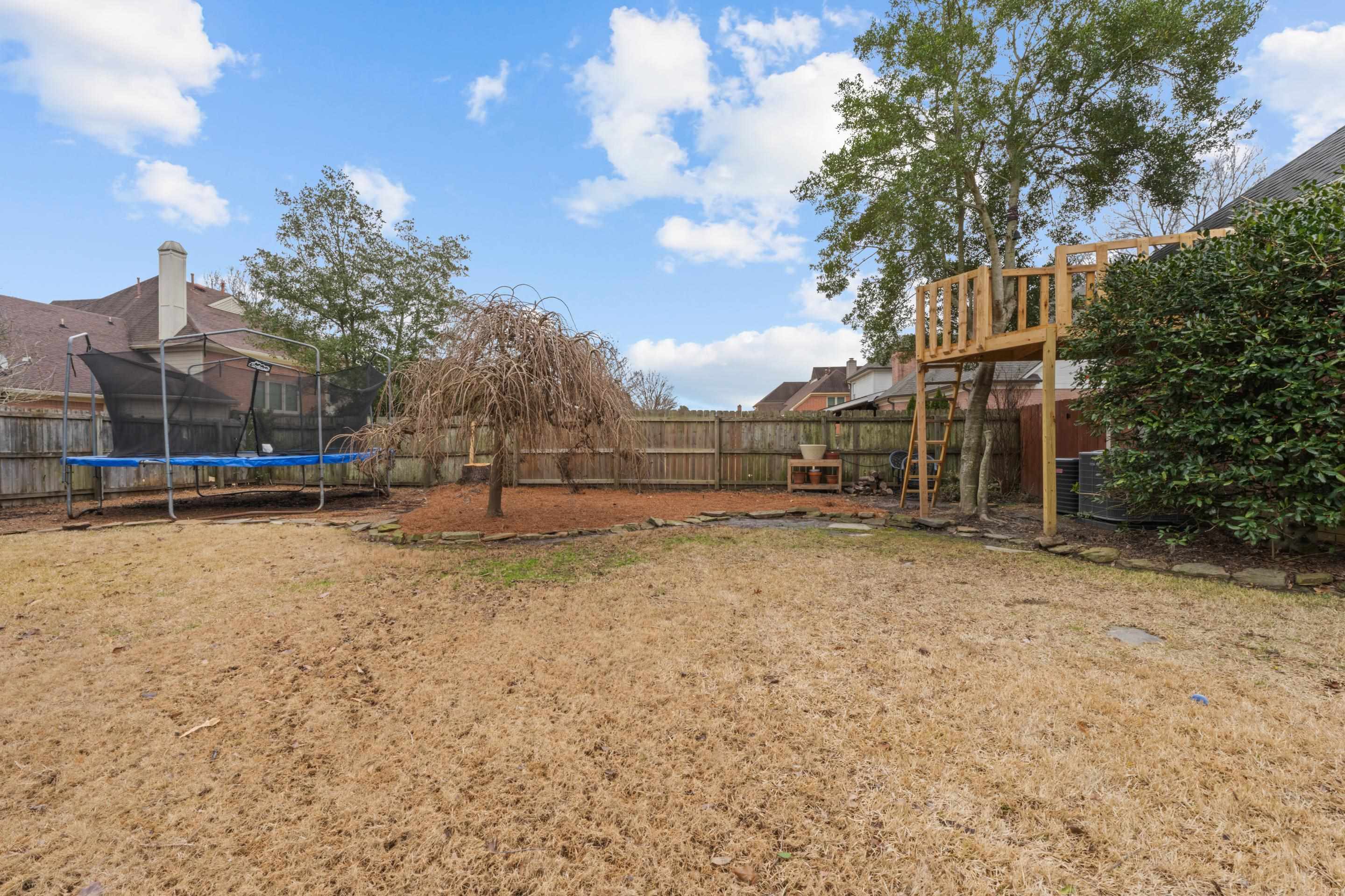 1594 John Ridge Drive Collierville, TN 38017 - Photo 24 of 29 View of yard with a trampoline and a wooden deck