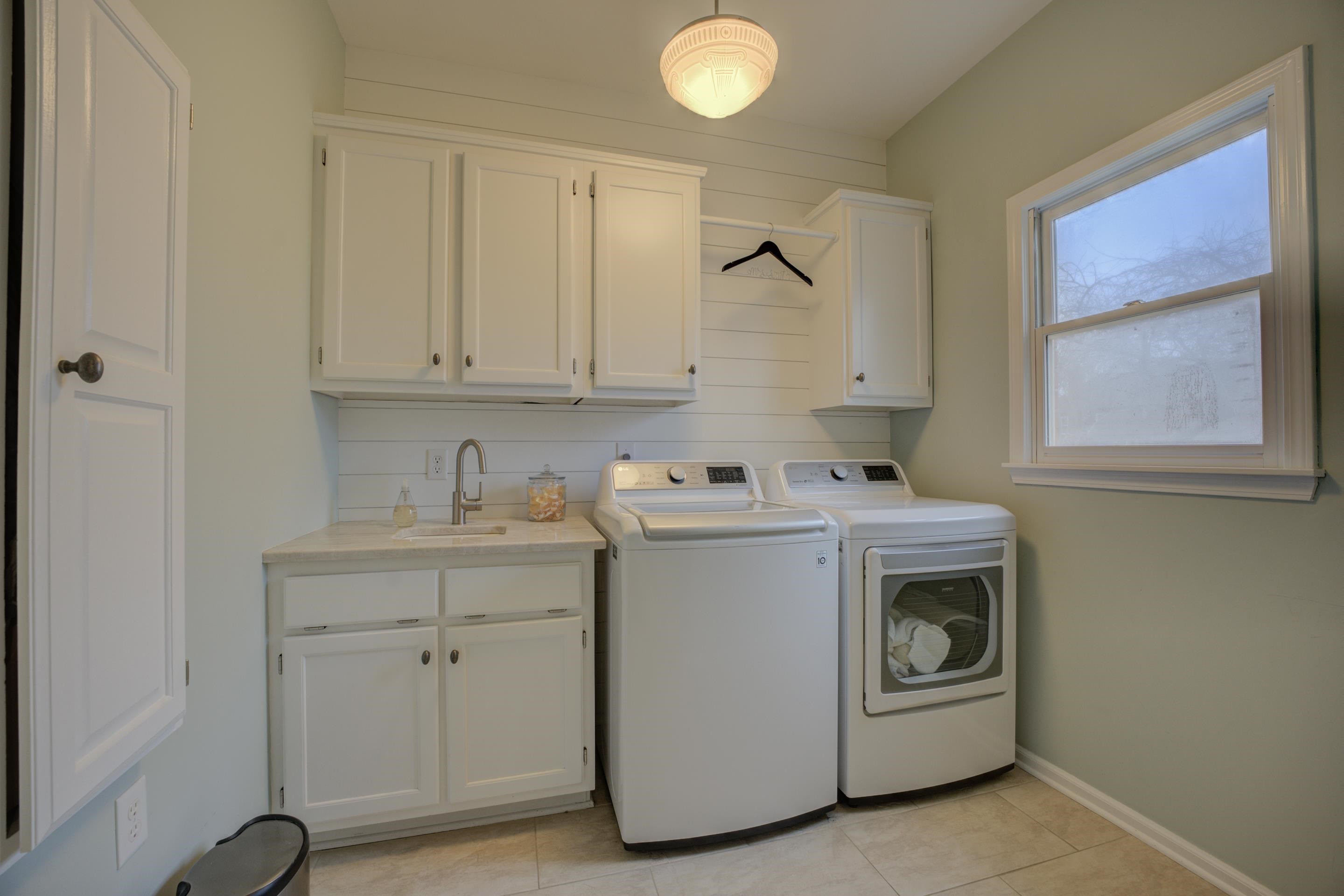1594 John Ridge Drive Collierville, TN 38017 - Photo 10 of 29 Laundry area featuring separate washer and dryer, sink, light tile patterned floors, and cabinets
