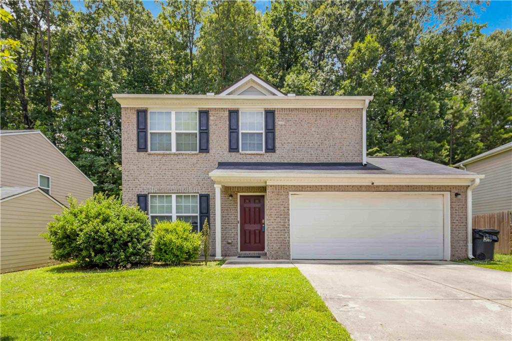 a front view of a house with a garden and yard