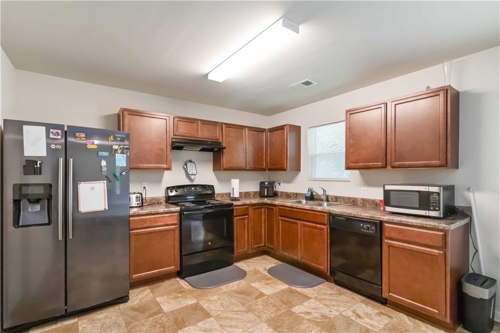 5622 Laurel Ridge Drive Atlanta, GA 30344 - Photo 4 of 23 a kitchen with stainless steel appliances granite countertop a sink stove refrigerator and cabinets