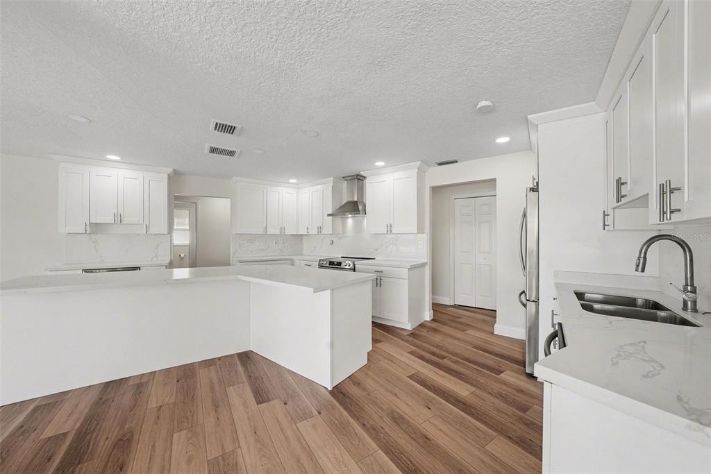 5041 Cabrilla Court New Port Richey, FL 34652 - Photo 15 of 43 a large kitchen with kitchen island a sink stainless steel appliances and cabinets