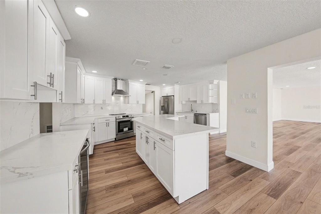 5041 Cabrilla Court New Port Richey, FL 34652 - Photo 17 of 43 a large white kitchen with white cabinets and stainless steel appliances