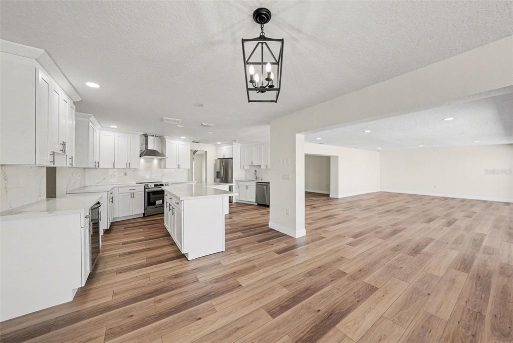 5041 Cabrilla Court New Port Richey, FL 34652 - Photo 19 of 43 a view of a kitchen with kitchen island white cabinets and wooden floor