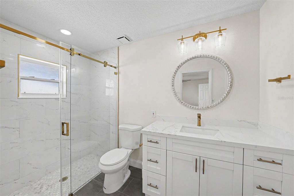 5041 Cabrilla Court New Port Richey, FL 34652 - Photo 32 of 43 a bathroom with a toilet sink vanity granite and a mirror