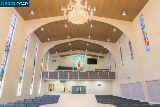 a living room with furniture a flat screen tv and kitchen view