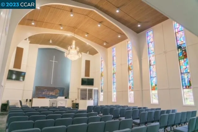 a living room with furniture a flat screen tv and kitchen view