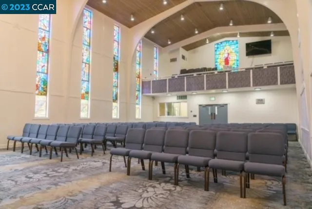 a large living room with couches a fireplace and a flat screen tv
