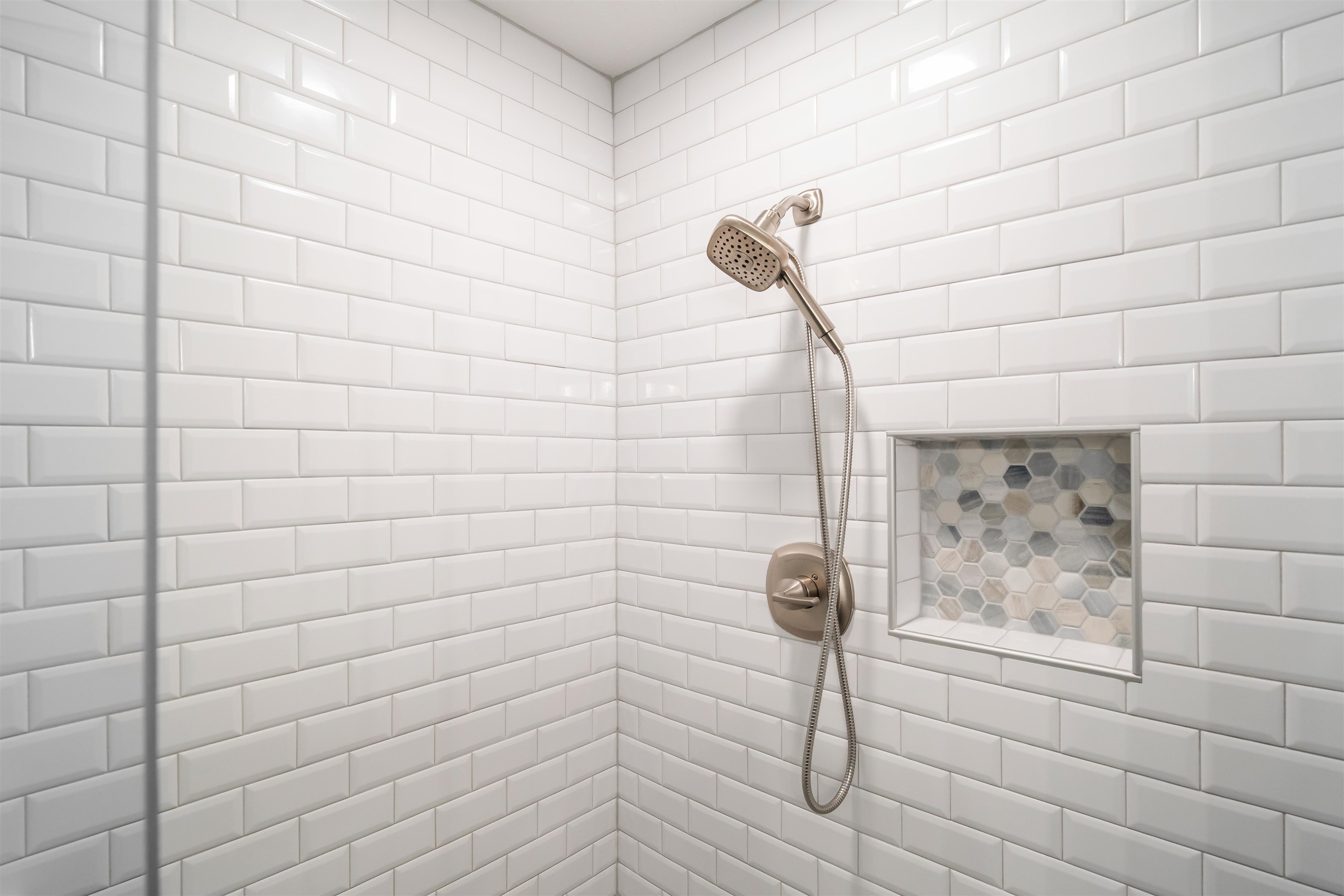 6943 Fords Station Road, Unit 64 Germantown, TN 38138 - Photo 24 of 30 Shower with white subway tile walls, brushed nickel showerhead and control, and a recessed niche featuring hexagonal mosaic tile