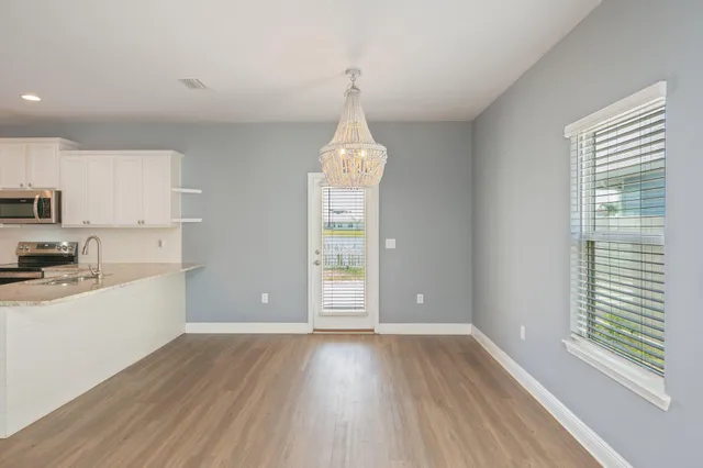 a kitchen with granite countertop white cabinets and stainless steel appliances