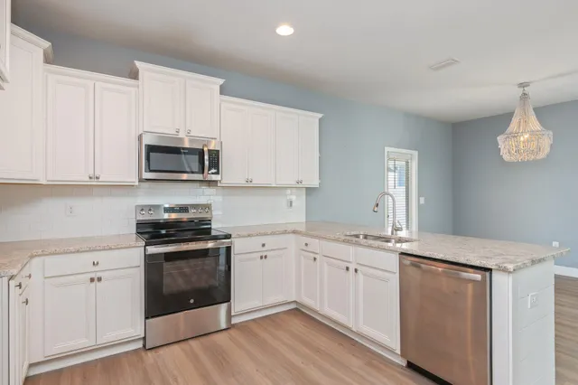 a bedroom with a large bed and a chandelier