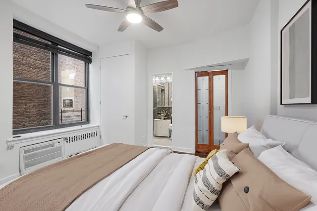 a bedroom with a bed and a large window